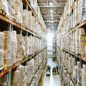 Spacious warehouse aisles lined with shelves stacked with boxes and packaging.