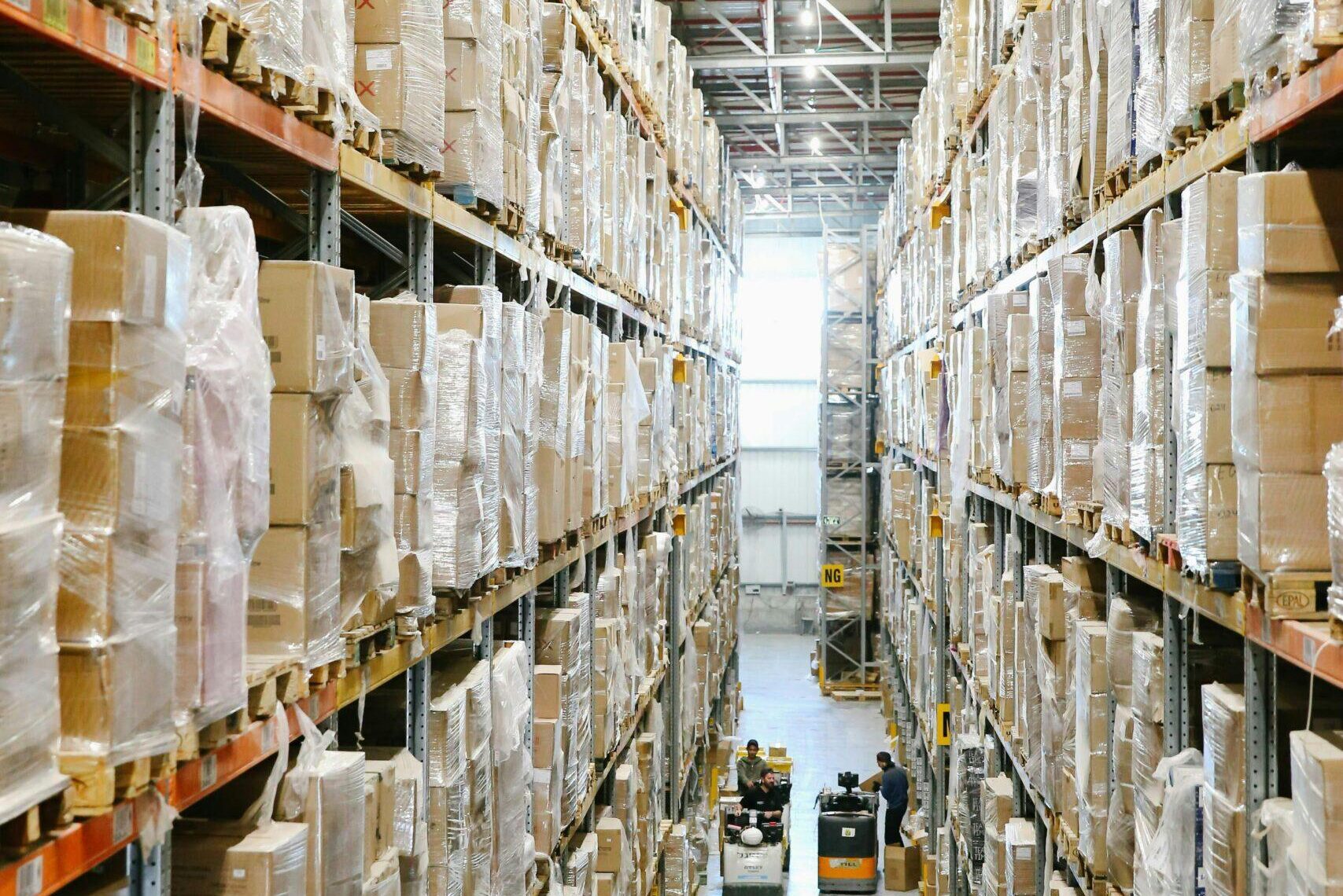 Spacious warehouse aisles lined with shelves stacked with boxes and packaging.